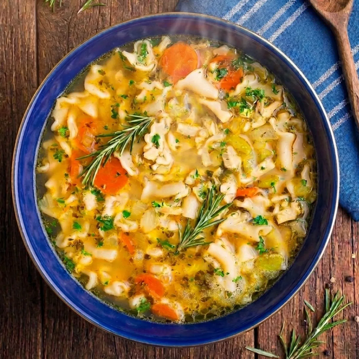 A comforting bowl of homemade vegetarian chicken noodle soup with wavy egg noodles and fresh herbs